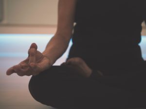 Expert tips on mindfulness meditation: A woman sits in lotus position meditating